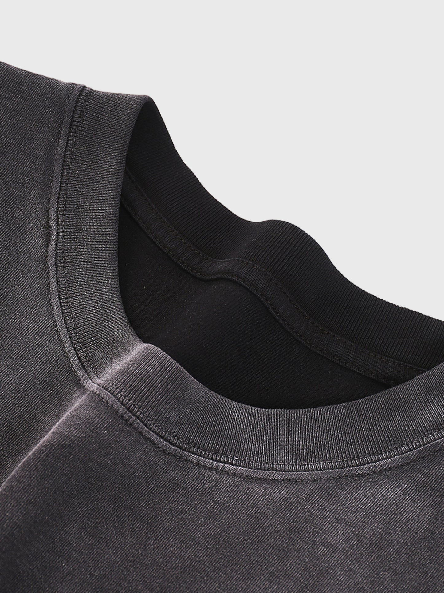 Close-up of a dark gray t-shirt collar on a light gray background