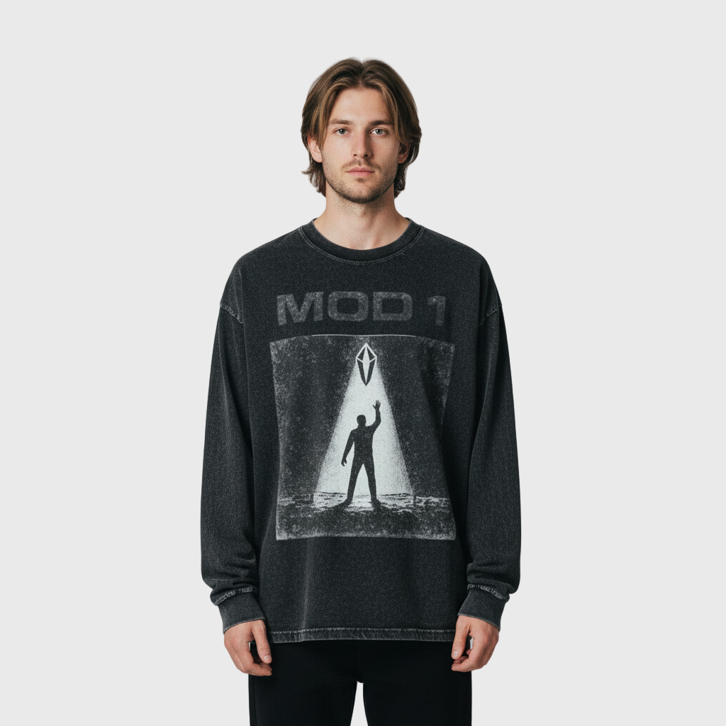 Person wearing a black MOD 1 T-shirt with graphic design on a gray background