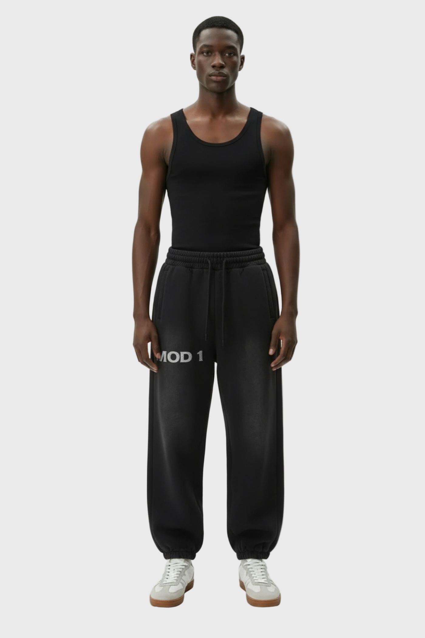 Person wearing a black tank top and black  MOD 1 pants with 'MOD 1' logo on a light gray background