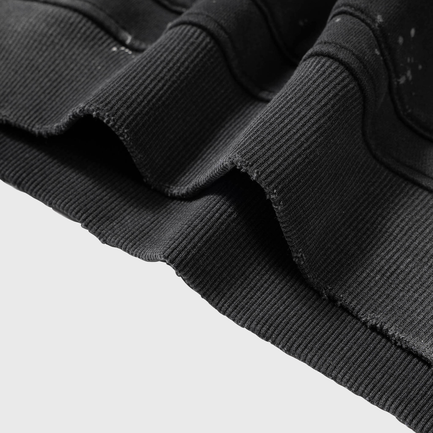 Close-up of black ribbed knit fabric on a MOD 1 Hoodie on a  white background