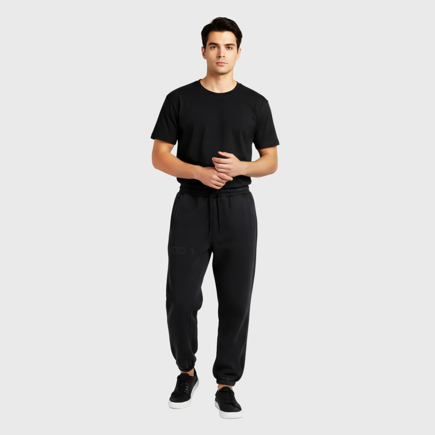 Man wearing a black t-shirt and black MOD 1 sweatpants with a MOD 1 logo on the right leg on a light gray background.