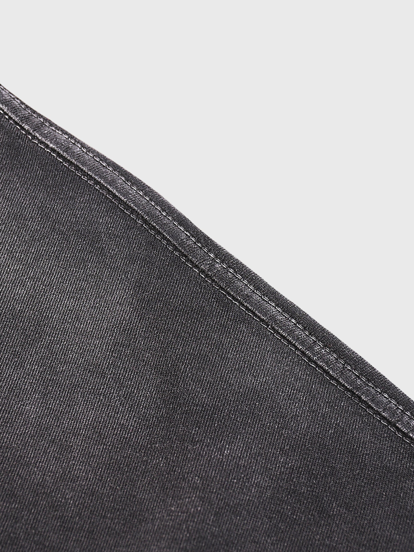 Close-up of black denim fabric with a white background