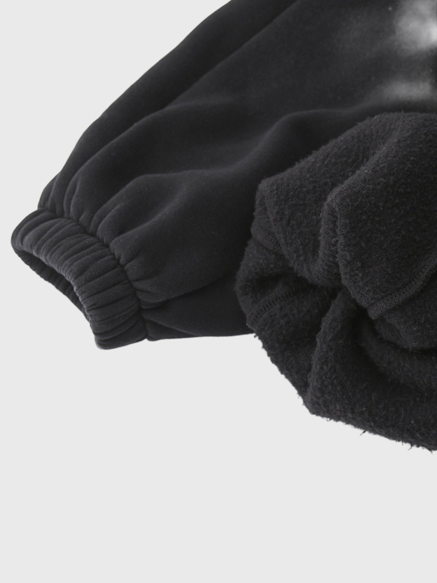 Close-up of black, acid washed MOD 1 sweatpants on a light gray background