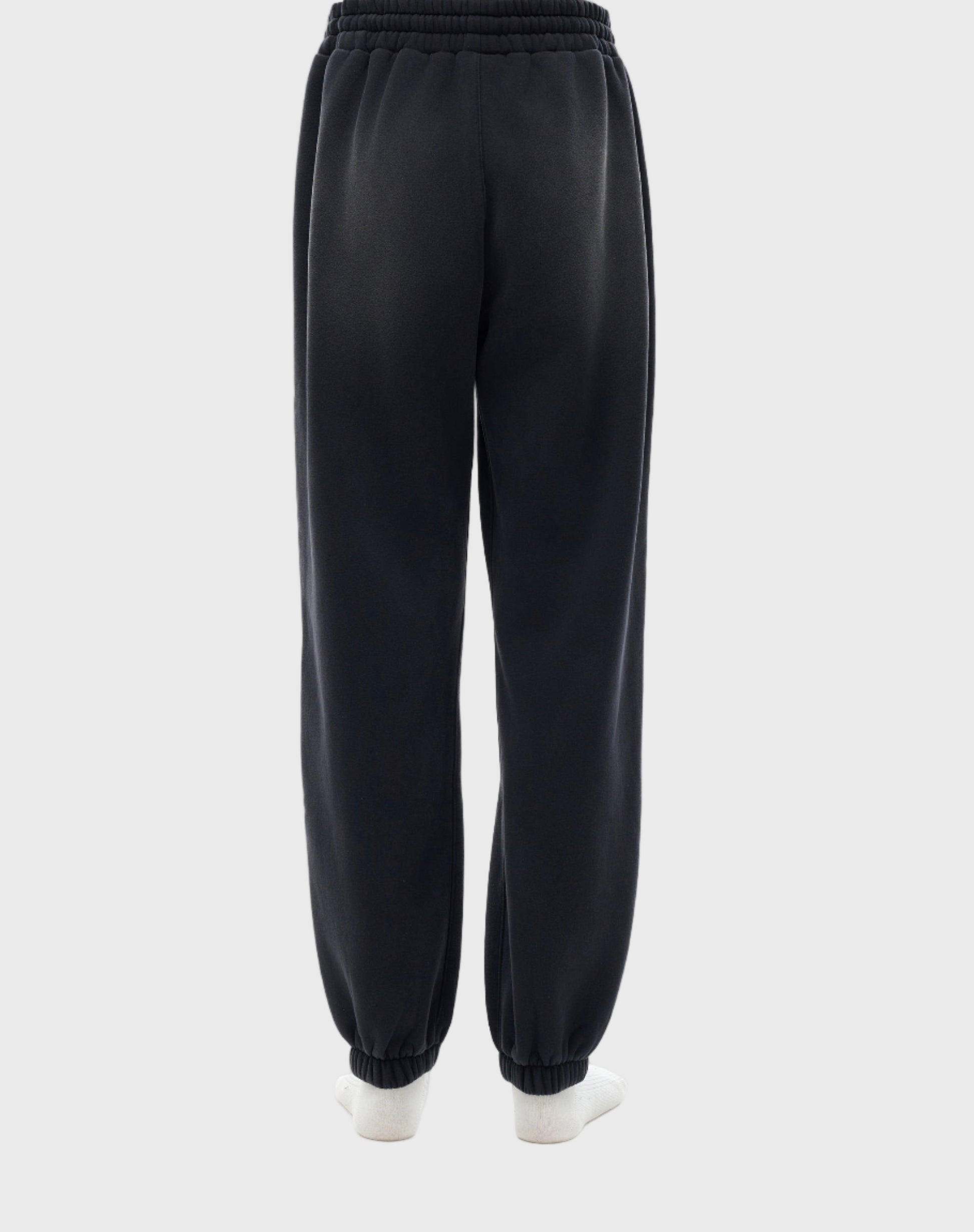Black MOD 1 sweatpants worn by a person on a light gray background